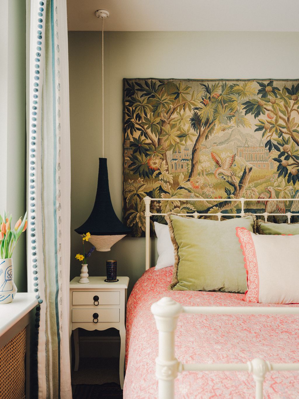 A spare bedroom is painted in Farrow Ball's ‘Hardwick White with an antique tapestry taking up the back wall. The...