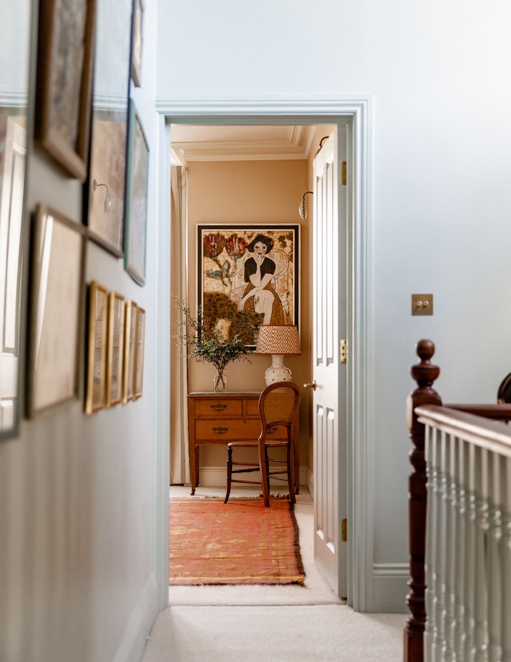In the main bedroom a painting by Barbara Robjant hangs above a vintage writing desk.