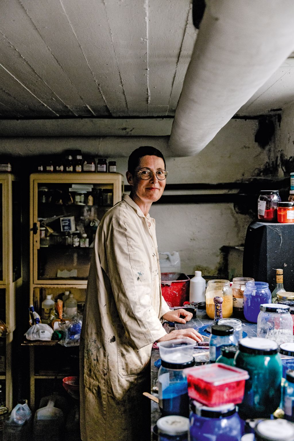 In the basement of their house Jacqueline grinds and mixes pigments using a glass muller to create casein paint.