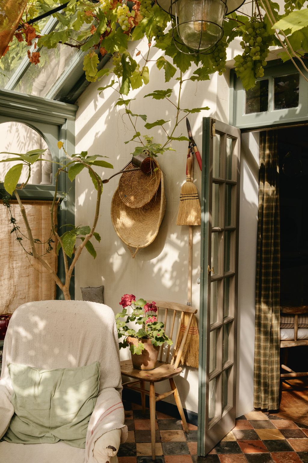 Leading off the kitchen the conservatory is painted in Farrow  Balls ‘Green Smoke