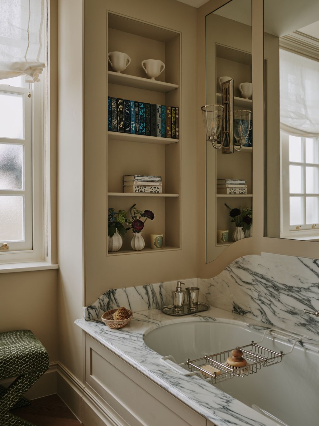 Wall panelling with mirrors and mounted wall lights along with the use of marble add glamour which is in keeping with...