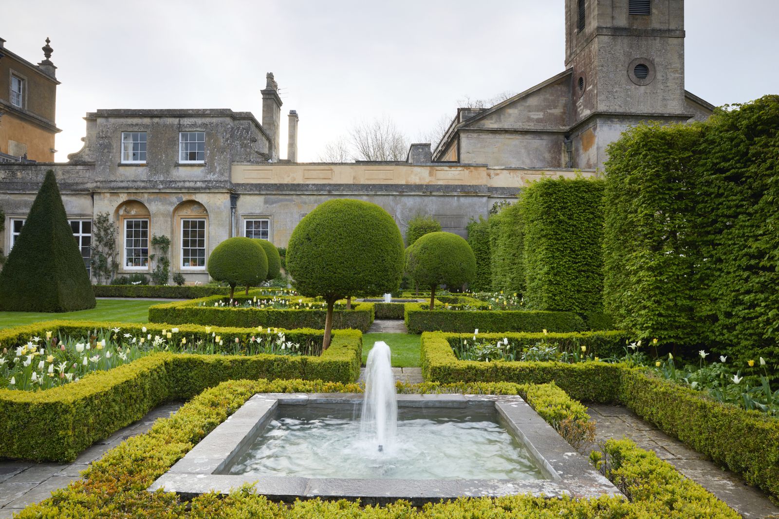 Simple fountains provide elegant focal points in the formal parterre in the south gardens. Box hedging delineates beds...