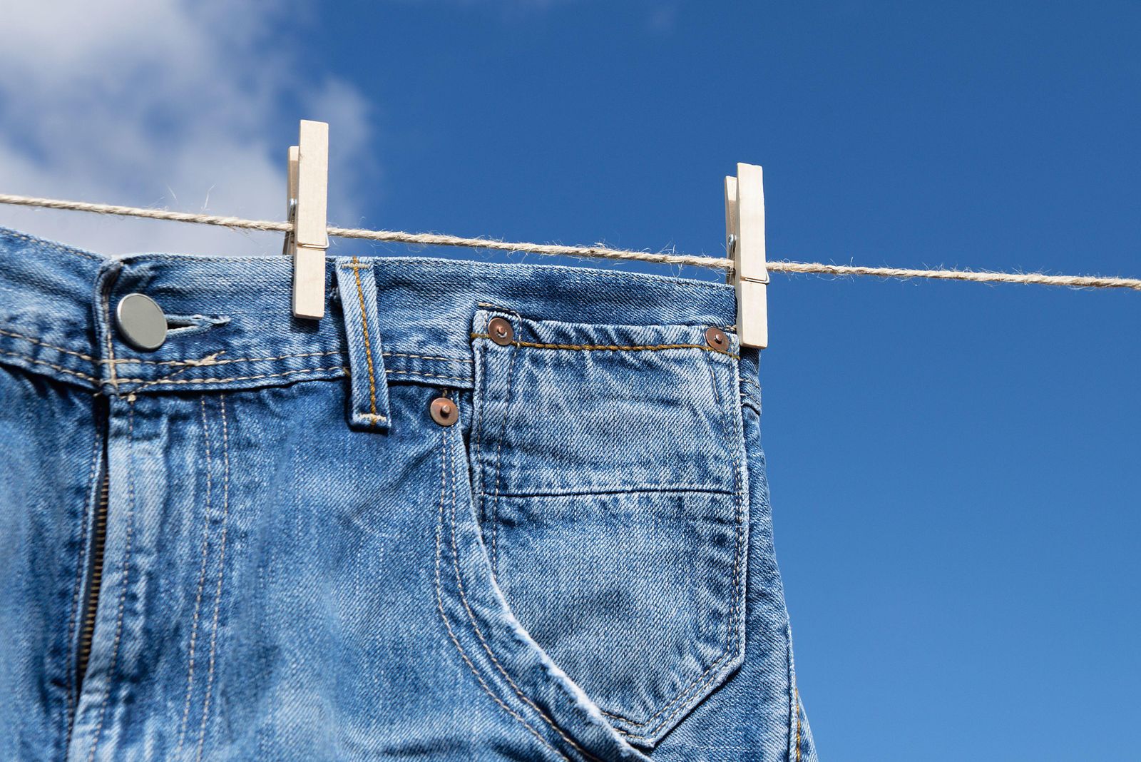 2MEG419 Jeans on a clothes line with blue sky in background