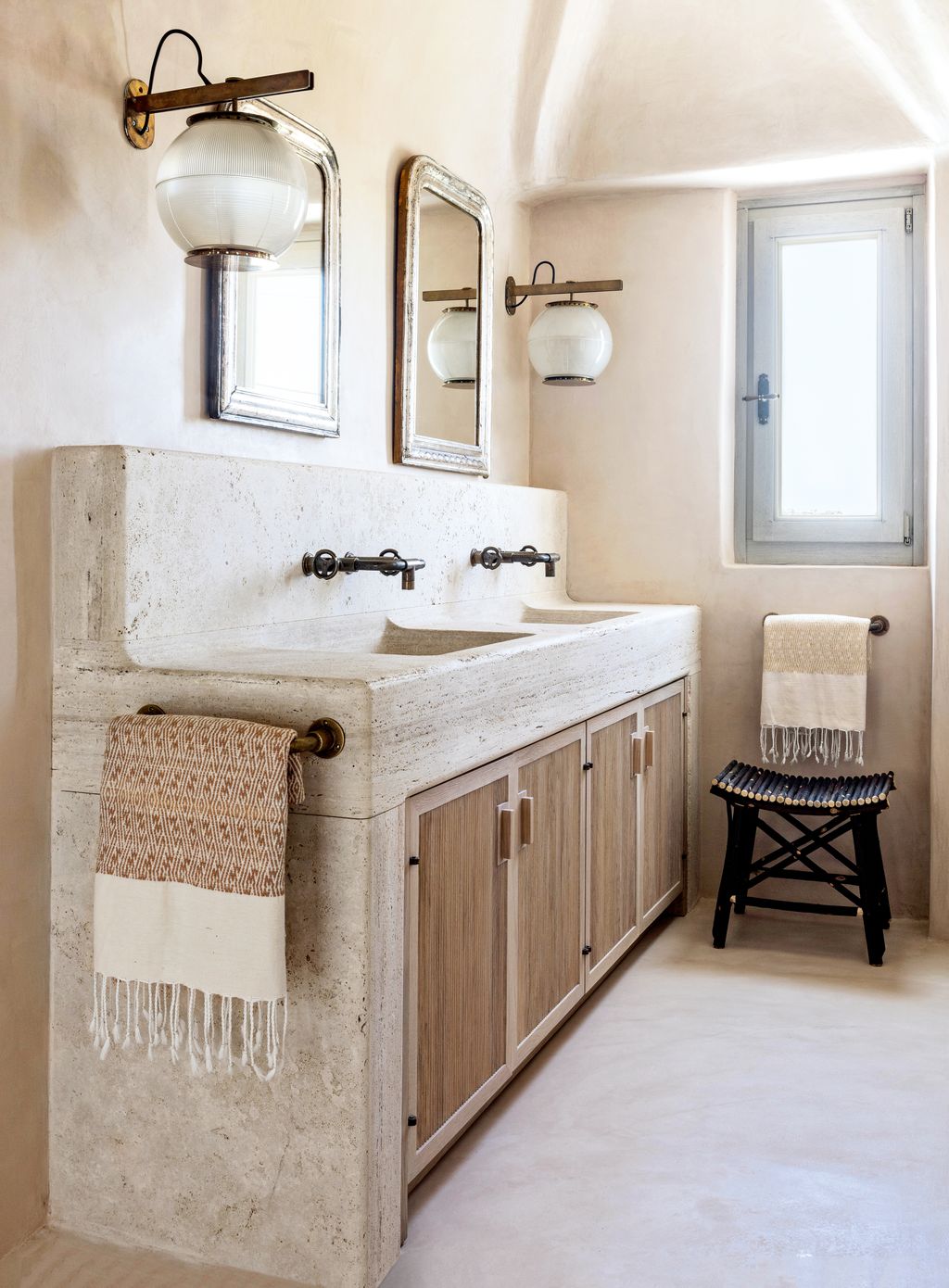 The bathroom has a double basin unit in travertine.