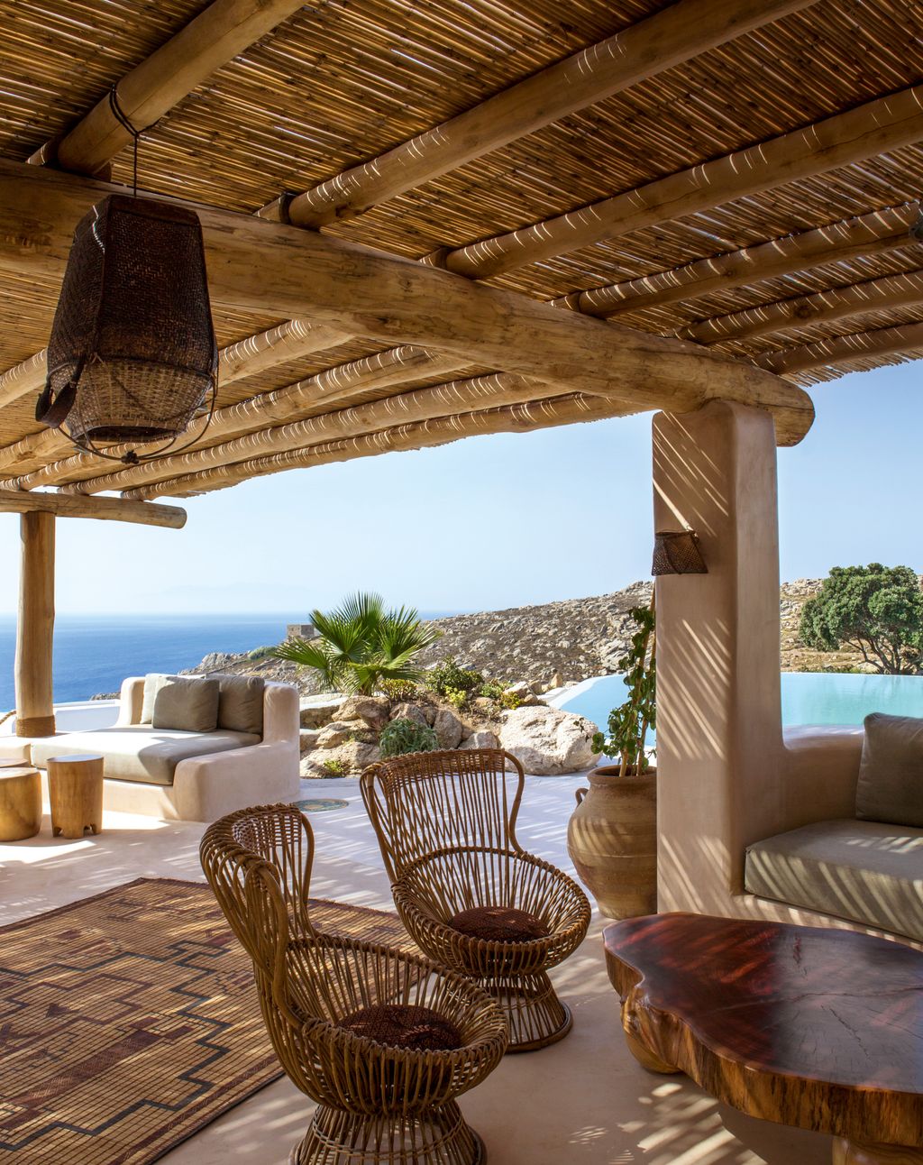 The bamboo roof of this timber structure creates dappled shade for builtin seating areas in coloured cement with views...