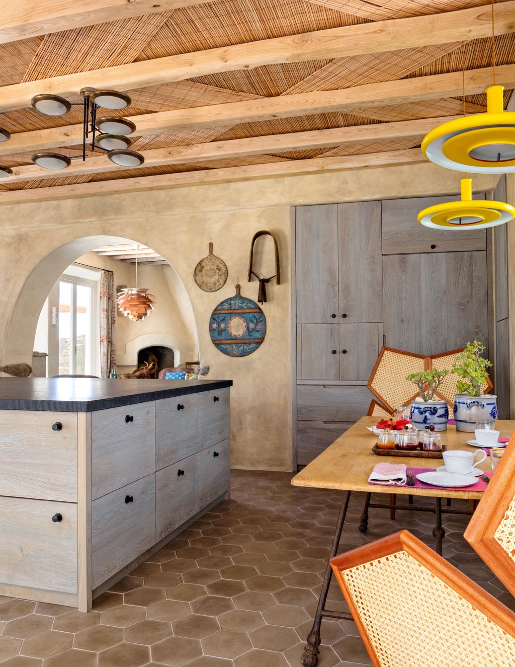 In the kitchen a Fifties chandelier by Stilnovo hangs above distressed oak units topped with Zimbabwe black granite.