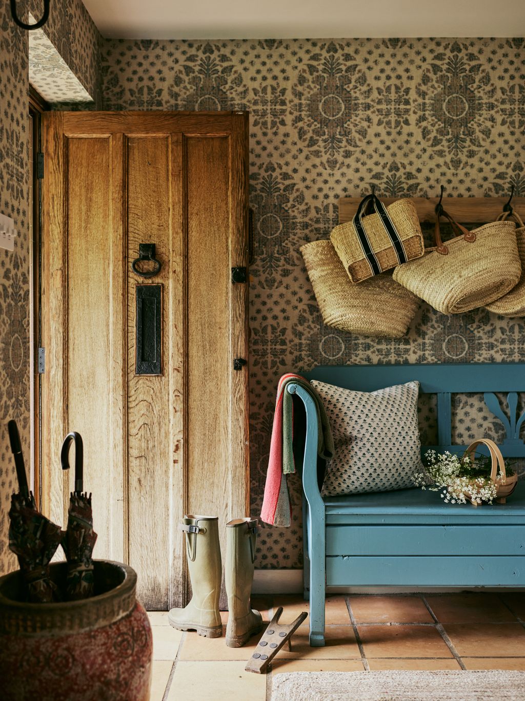 In the hallway the bench is from John Cornall Antiques painted blue by Lucy. It sits in front of Robert Kime ‘Karabak...
