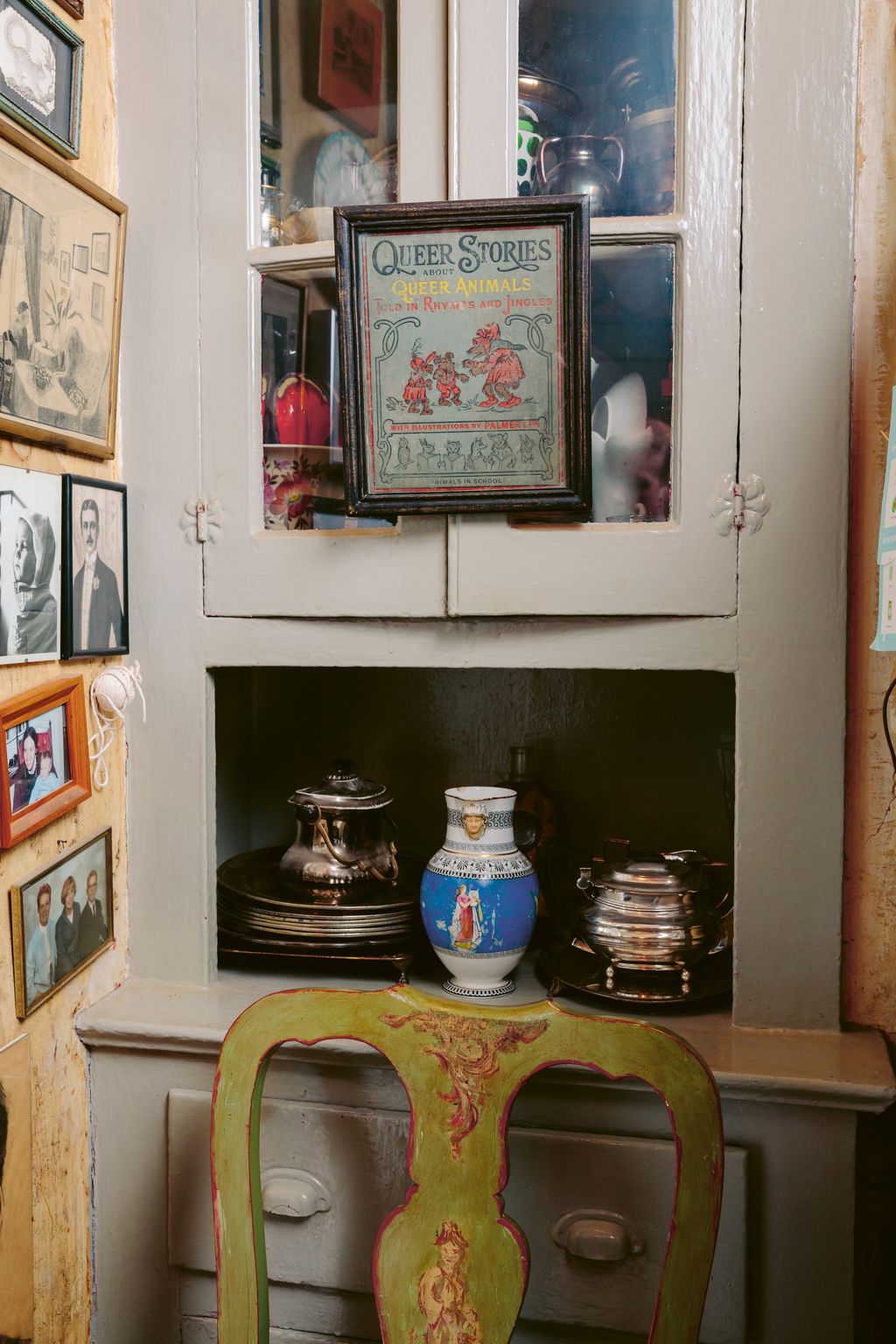 Antique photographs and framed book covers including Queer Stories about Queer Animals decorate this corner