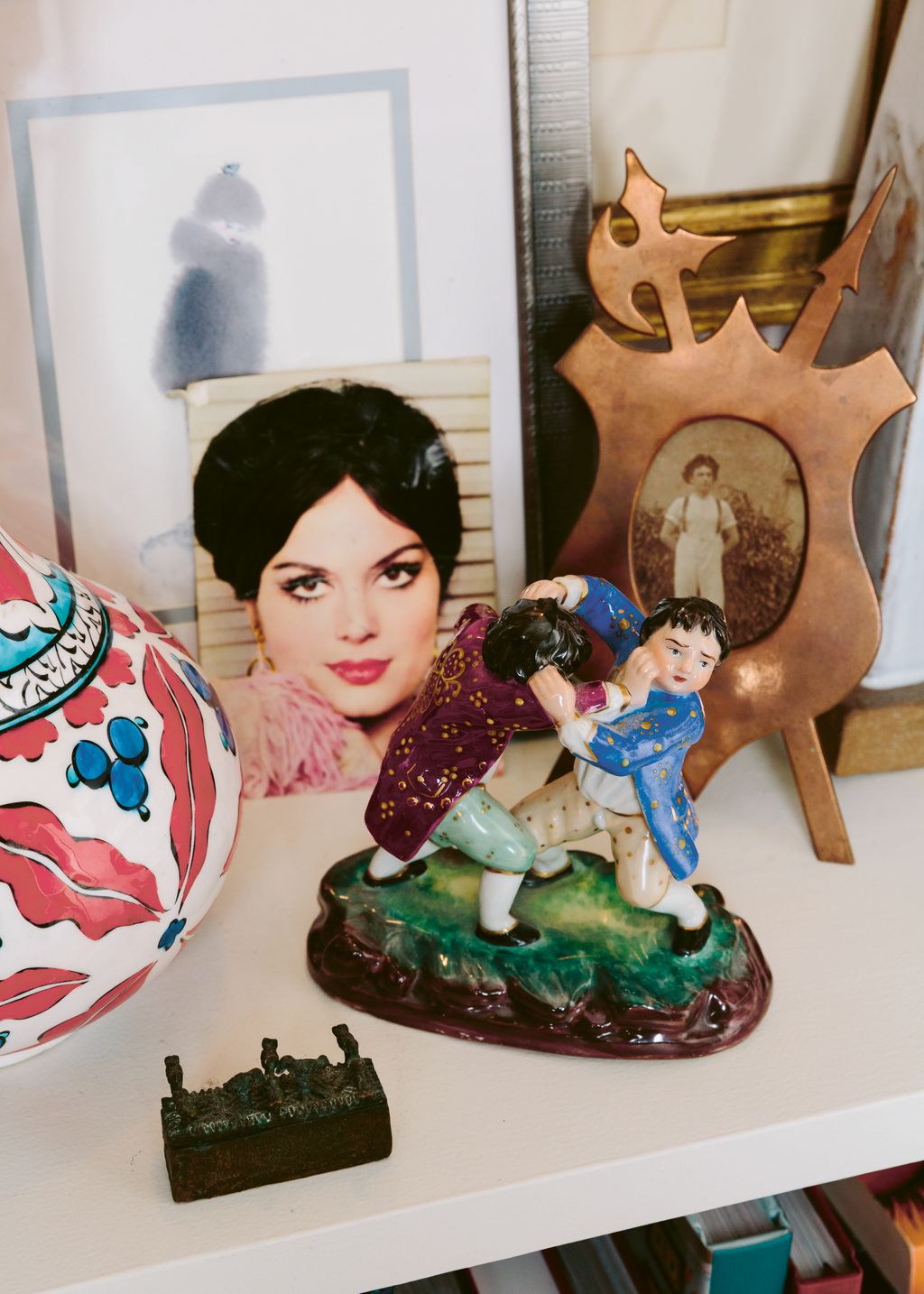 A low bookcase is topped by objets and mementos. Most of these are Turkish reflecting Sinan's heritage