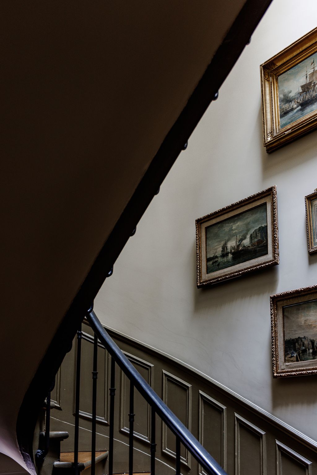 The 19th century boat paintings in the hallway are family heirlooms. The staircase spirals up to the top of the house.