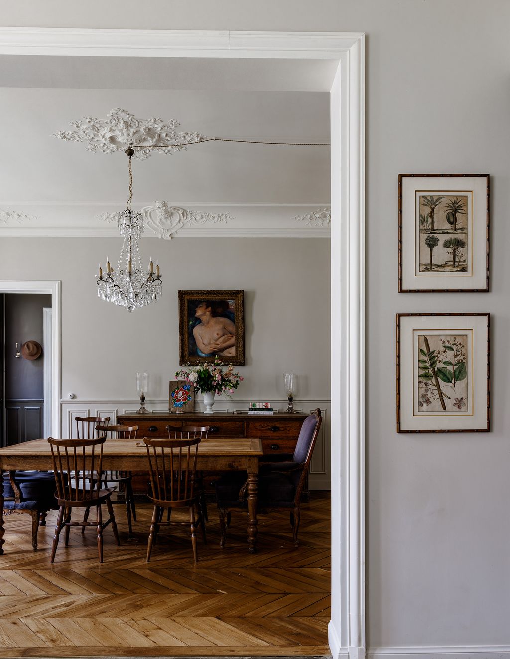 A painting of Alixs husbands grandmother hangs above a large credenza which was once used for storage in a DIY shop.