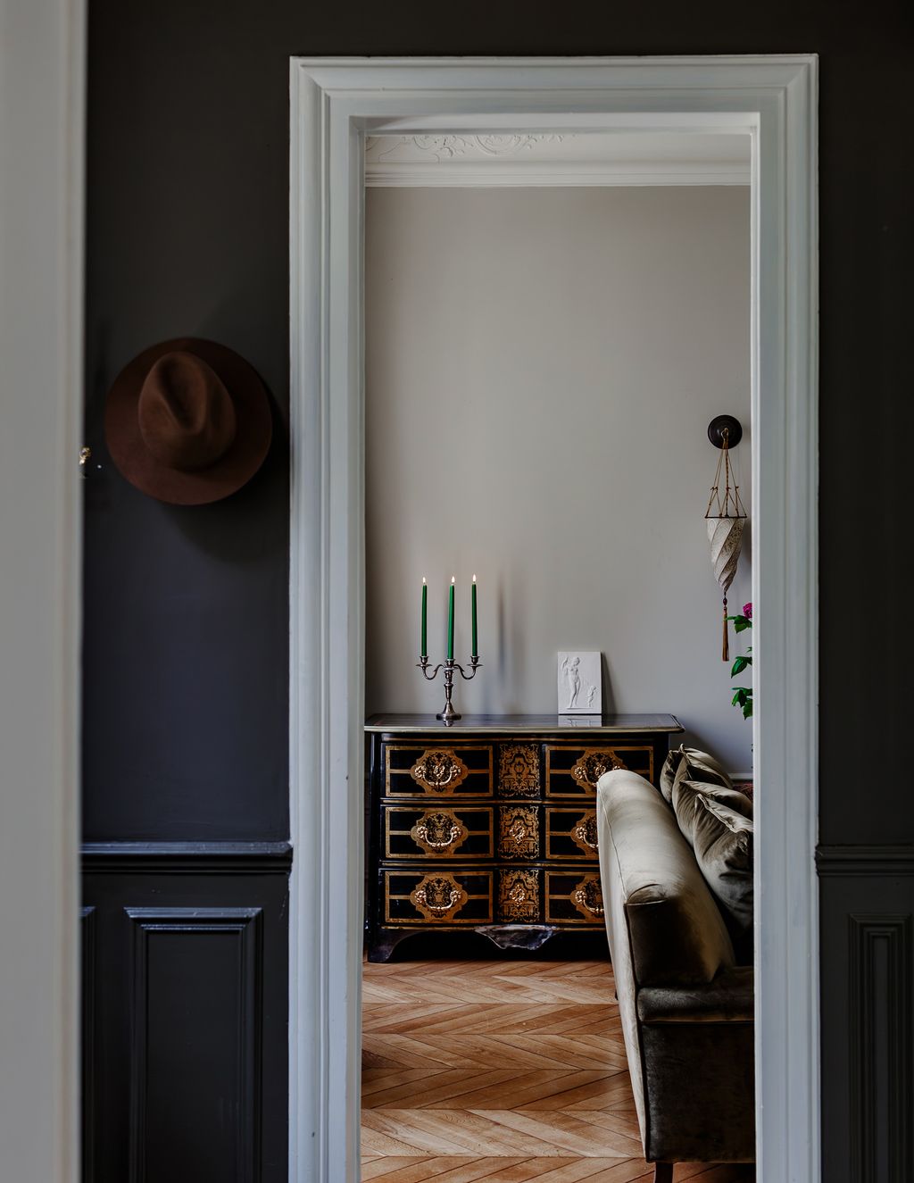Across the hall is the sitting room. The black commode is in the Boulle style and has its roots in the Louis XIV period.