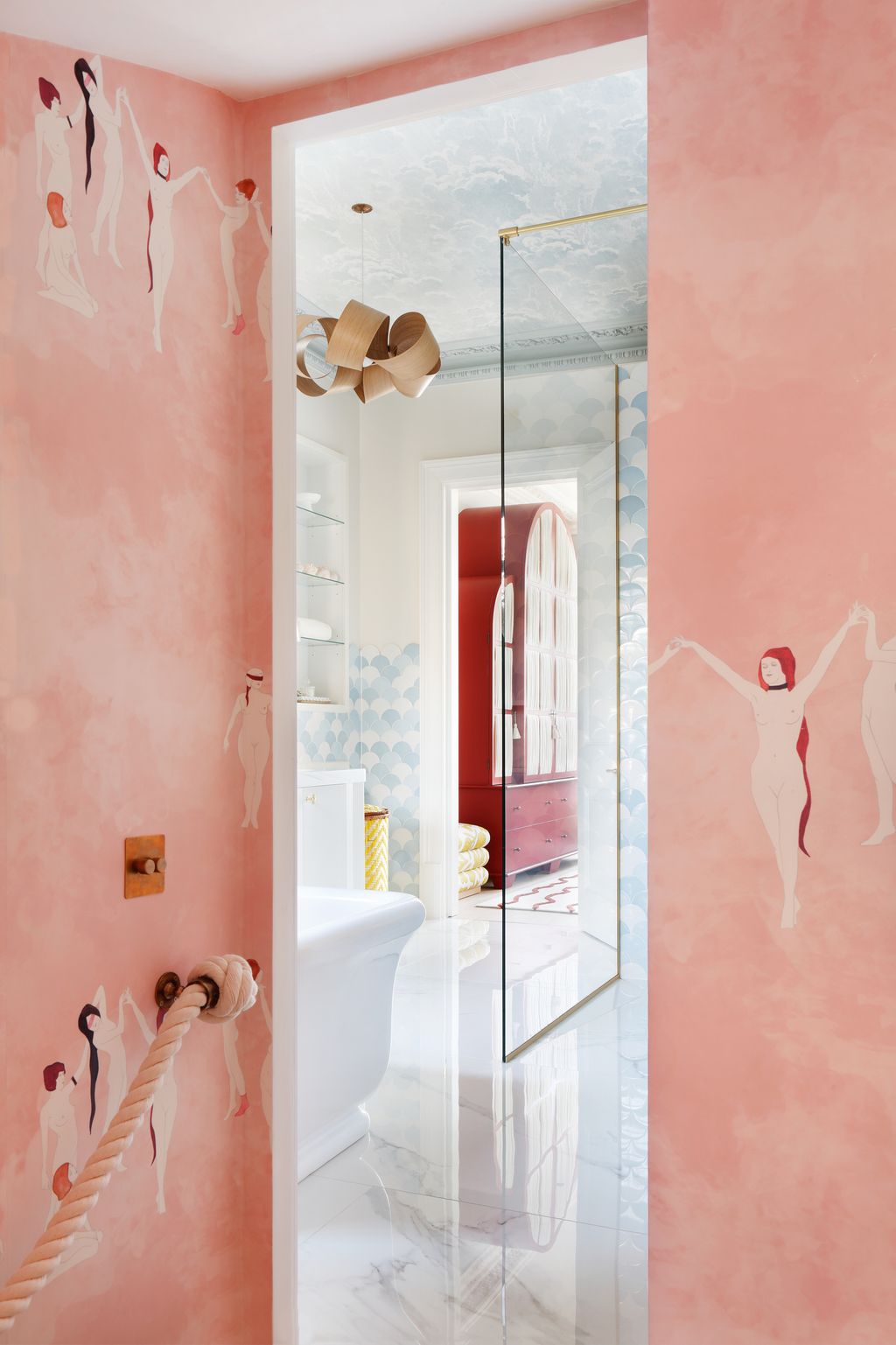 A Tom Raffield pendant seen from the dressingroom stairs in Maison Cs ‘Coven wallpaper in goldwyn pink is set off by...
