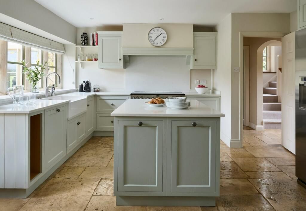 The kitchen is bright and airy and features a light limestone floor.