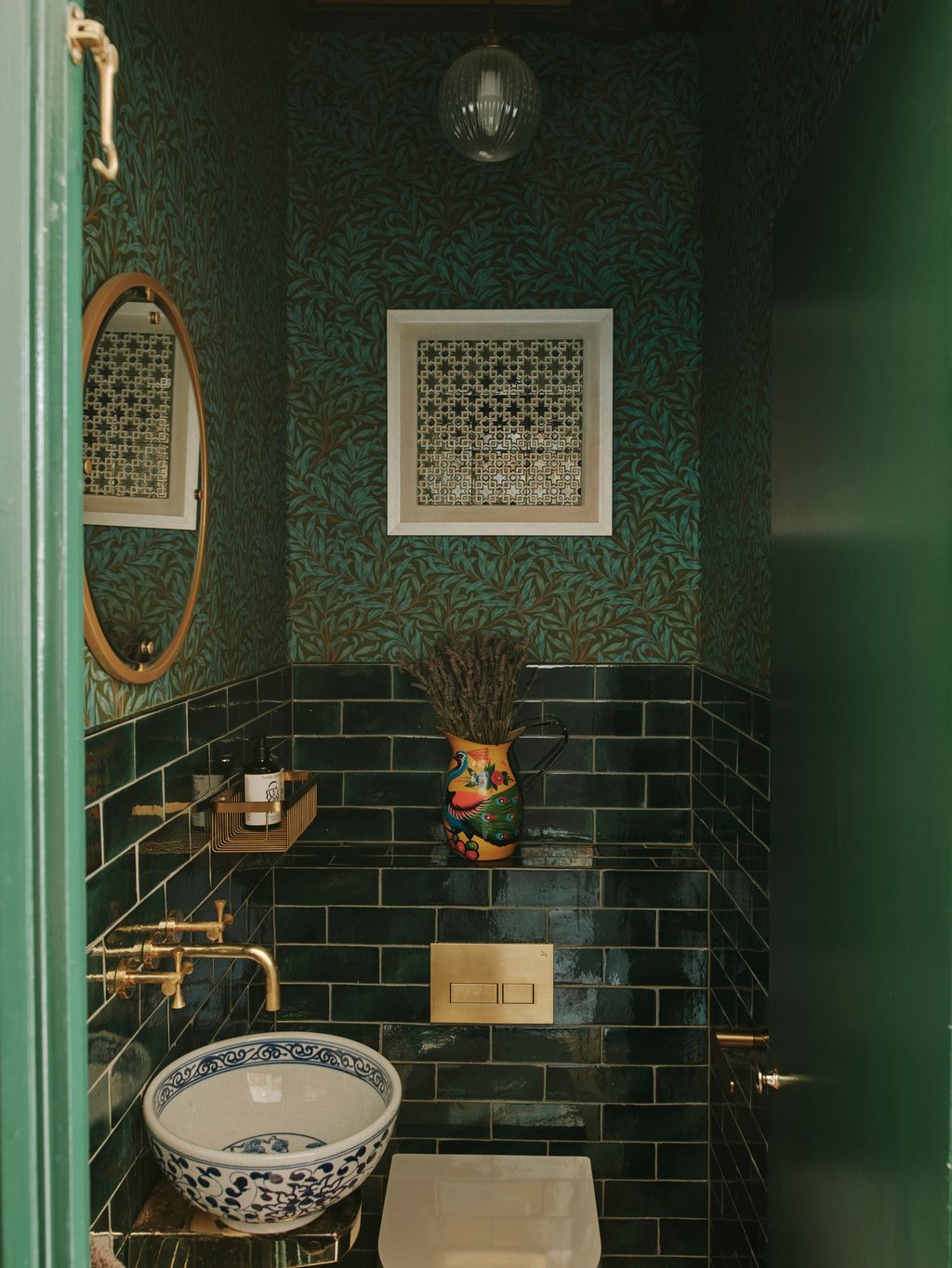 Tiles can also be a great option for downstairs loos. The artist Natasha Mann has used glossy dark green tiles combined...