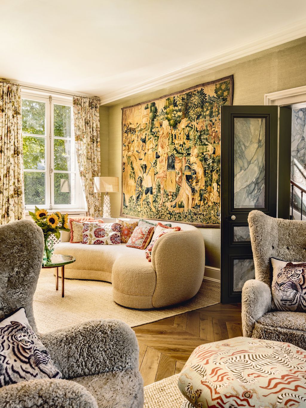 Above Lauras ‘Fuji sofa in snow wool is an 18thcentury tapestry and vintage teddy chairs are teamed with a stool in...