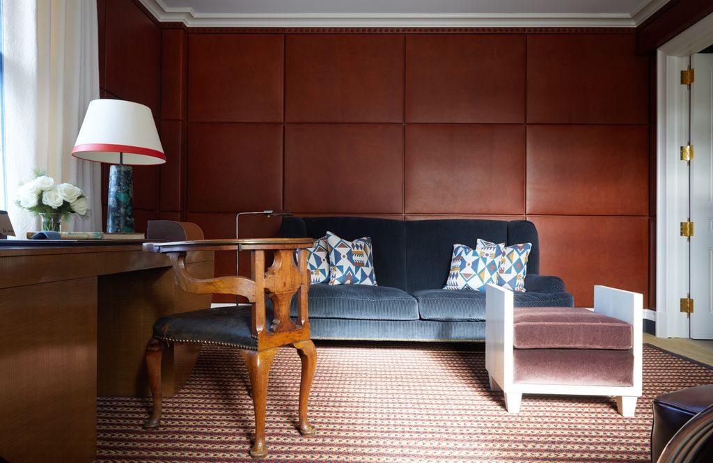 The walls of the gentlemans study are upholstered in leather panels