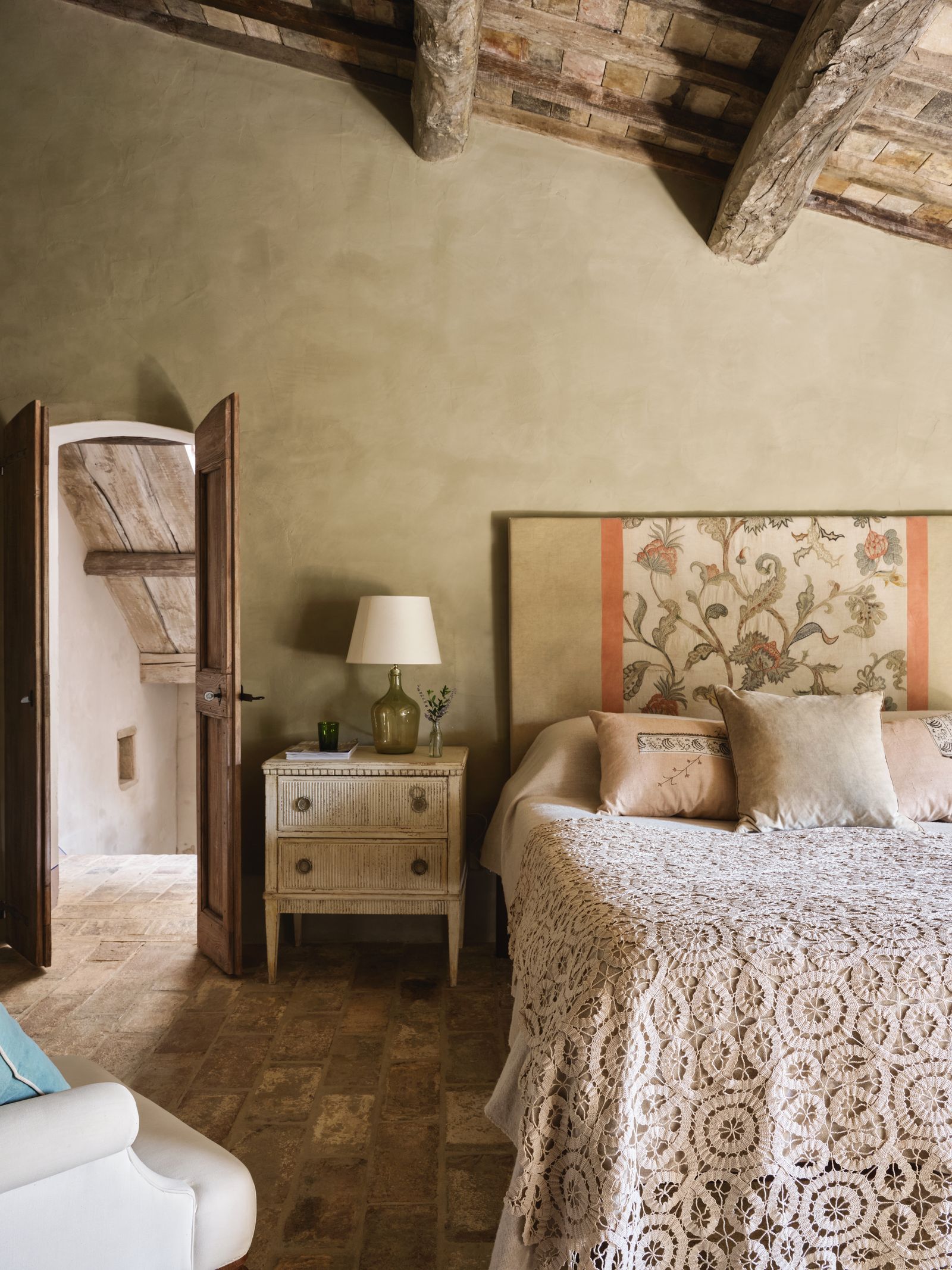 A crewelwork panel on the headboard was the starting point for the decoration of this bedroom in an Umbrian farmhouse.