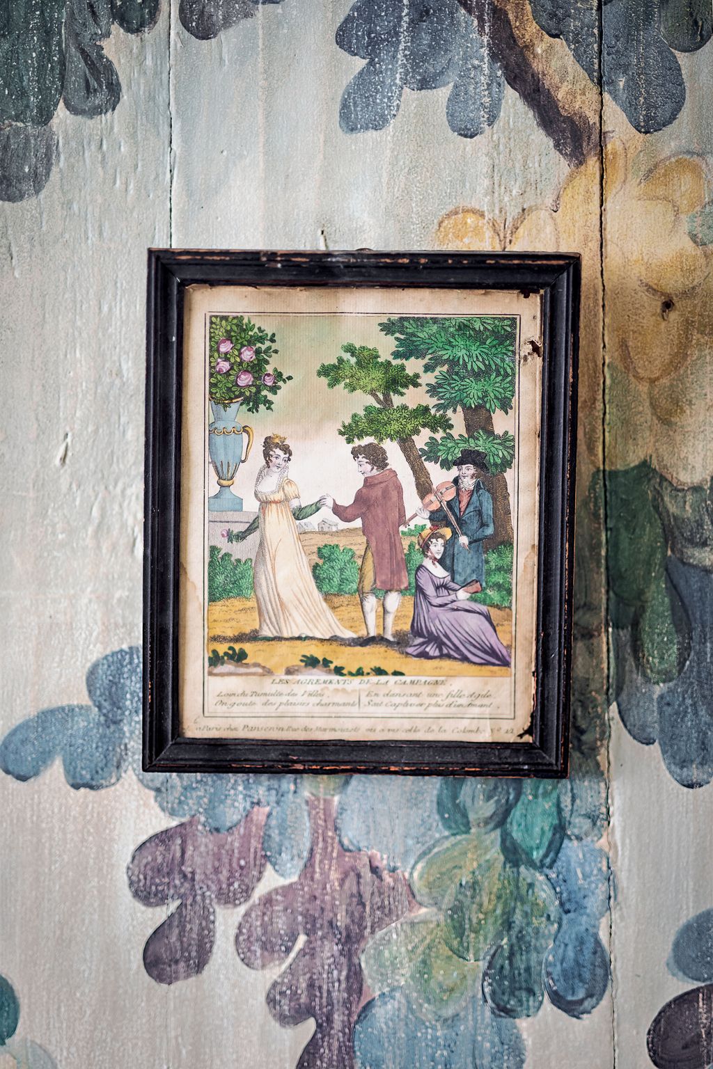 An Empireperiod gouache engraving 'Les Agrments de la Campagne' hangs on the hand painted wall.