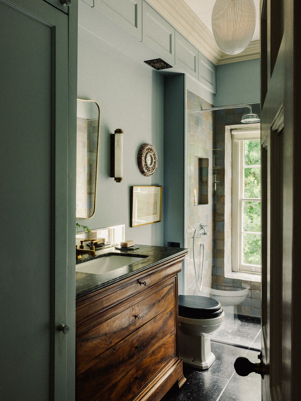 A generous vanity unit made from a repurposed Charles xxc.commode makes this bathroom feel like an extension of the...