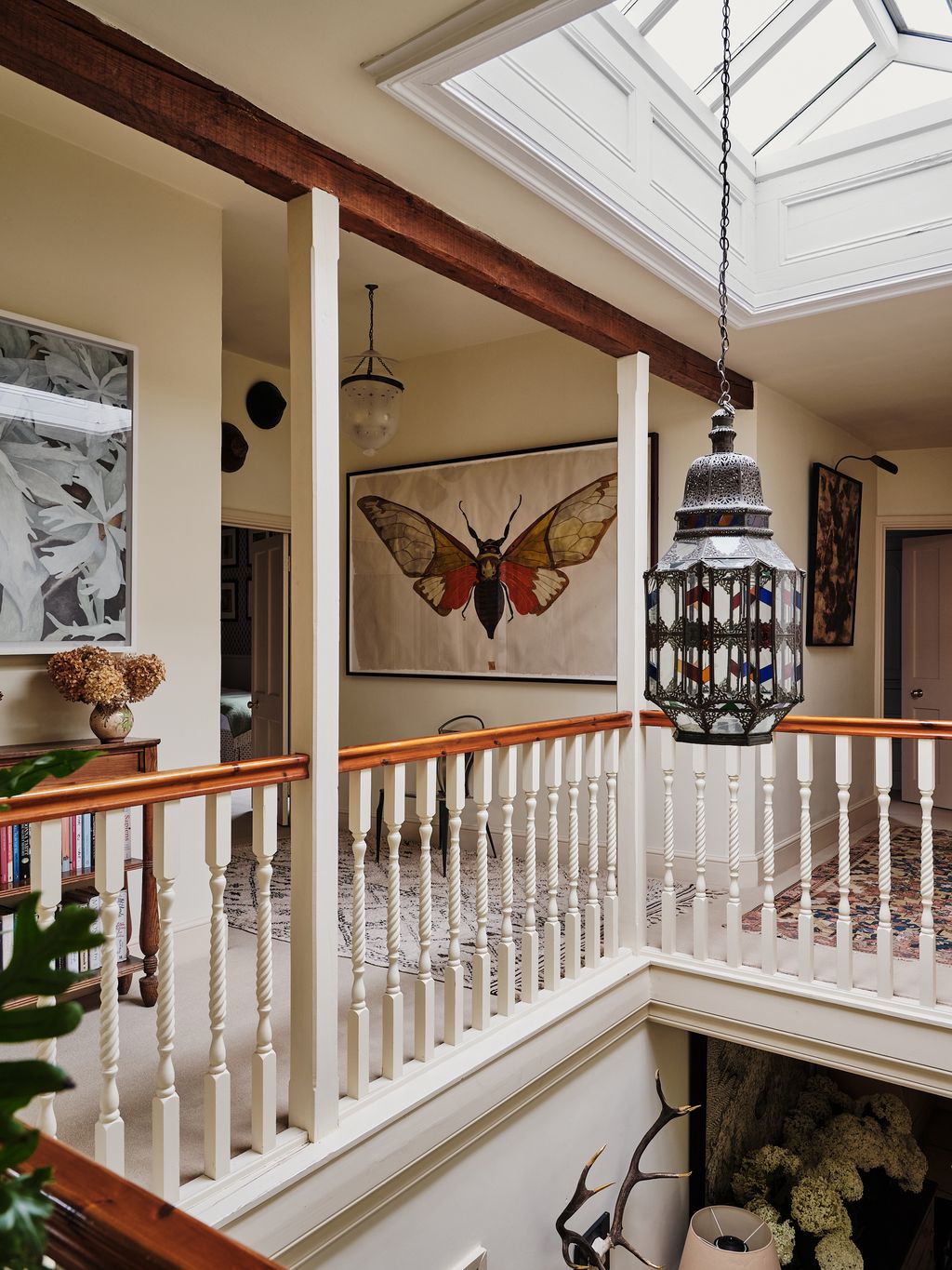 In the hall hangs a botanical painting by Endellion Lycett Green and a large moth by Sarah Graham. The lantern is from...