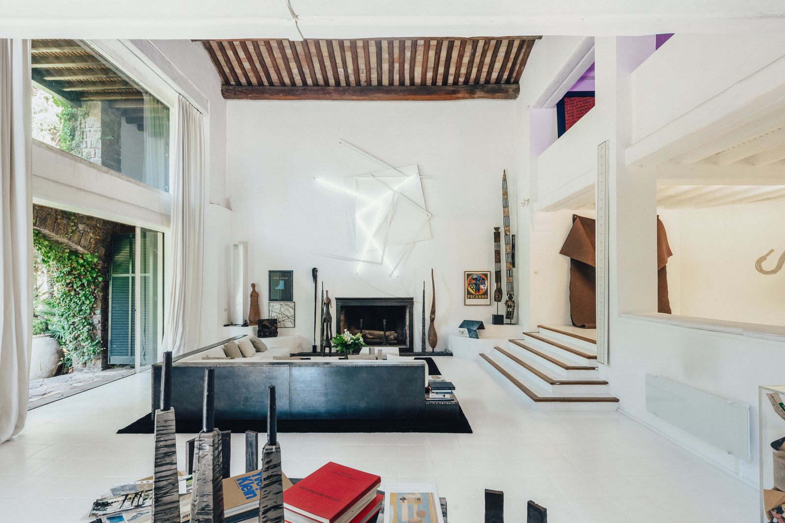 The sitting room at Le Moulin has a sofa table and candlesticks designed by Bernar and artwork collected by him and...