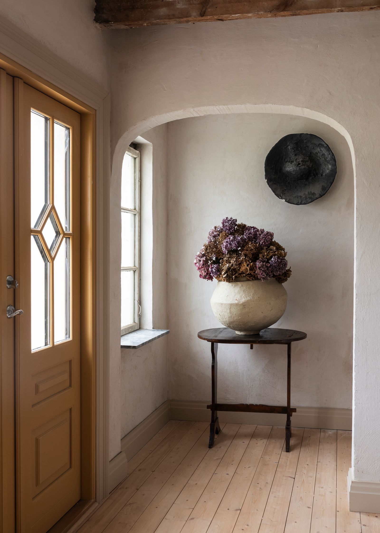 The table and vase are antique and the wall sculpture is by Rebecca Charlez.