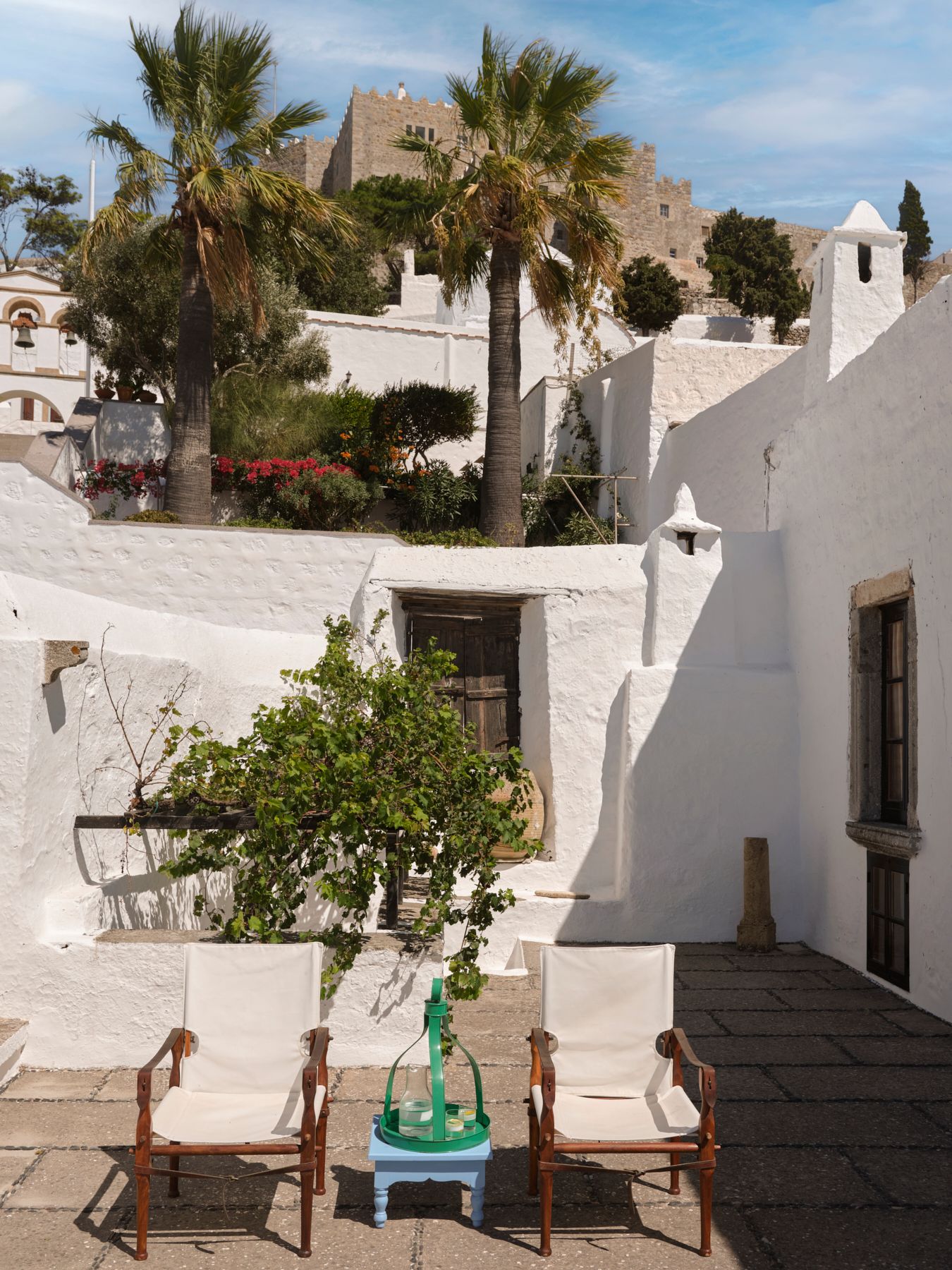 Looking back from the upper terrace the white houses of the Medieval town on Chora unfold uphill towards 11thcentury...