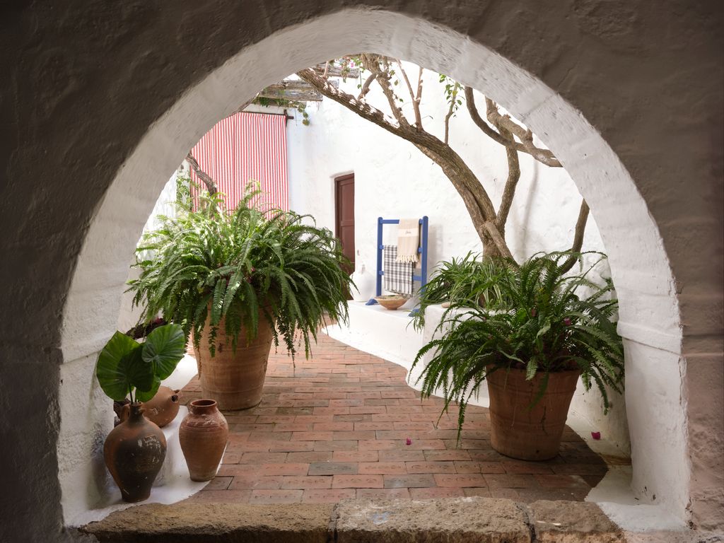 An earlyseventeenthcentury pointed arch leads to a courtyard of the old Moscoudi house with bougainvillea and jasmine...