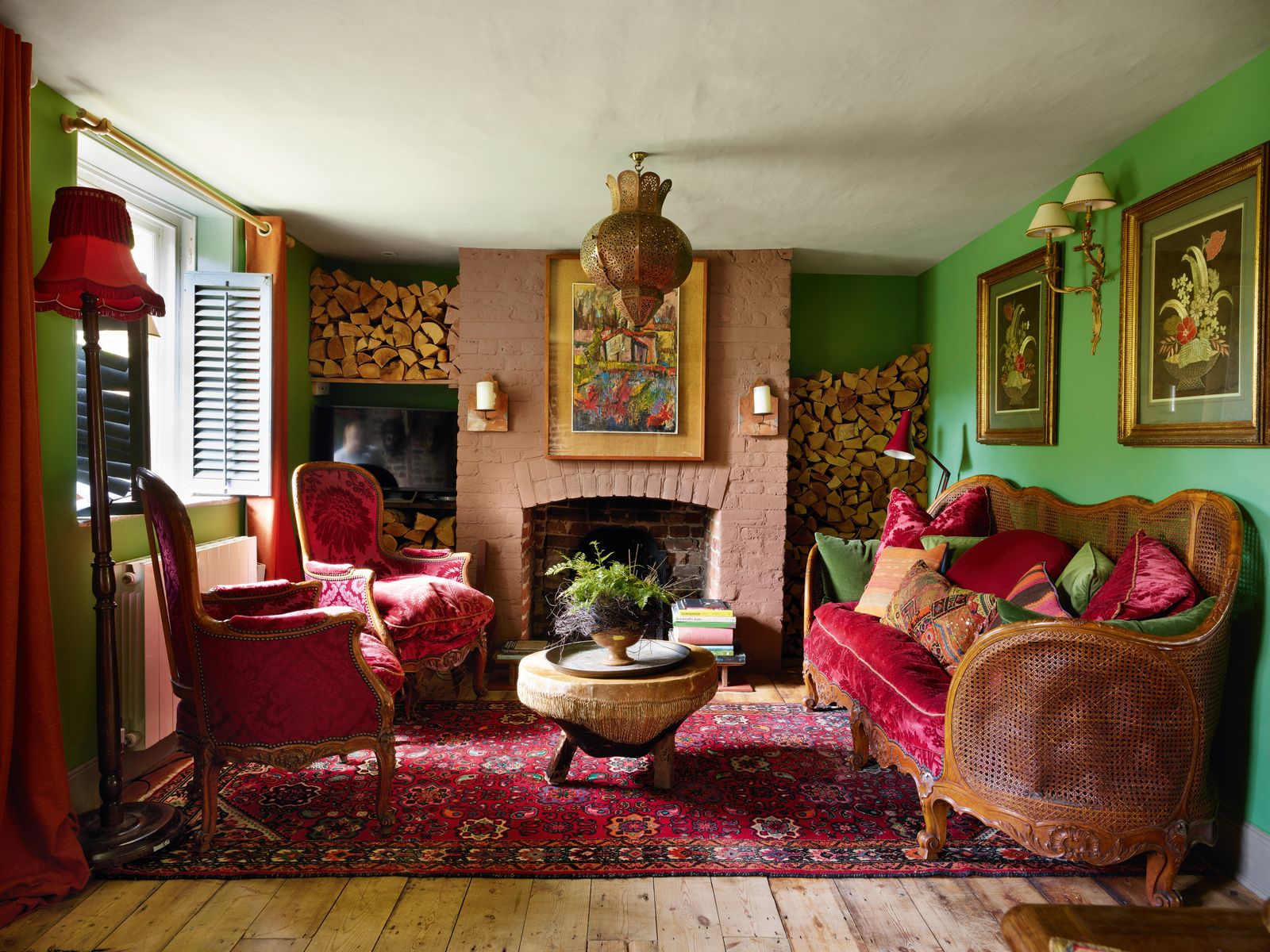 A French Louis XVstyle bergère sofa and armchairs in claret velvet from Southgate Auction Rooms. African wooden masks an...