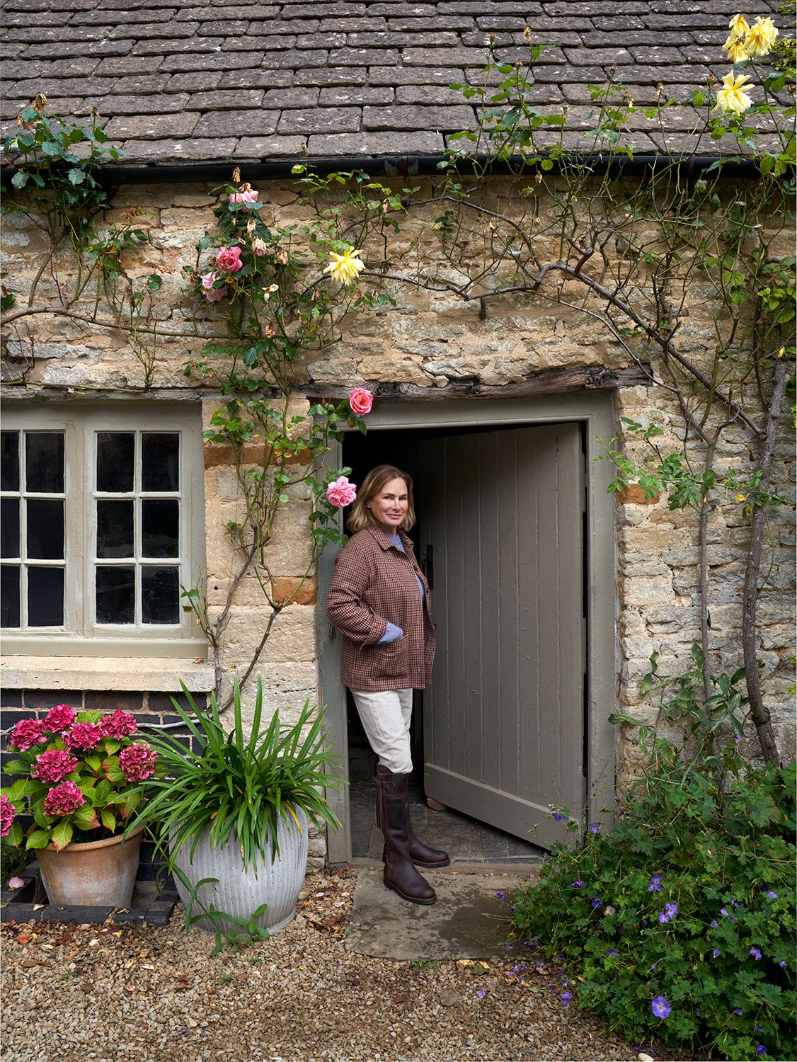 Penelope stands against the door of the bake house which is now used as a utility room. The garden is well stocked the...