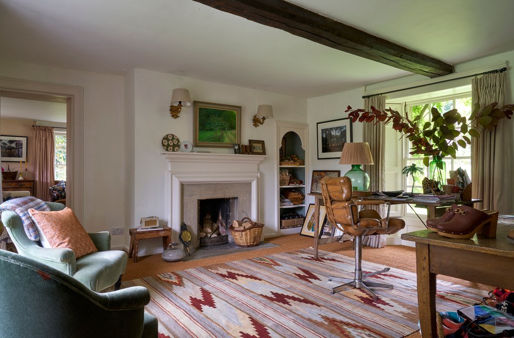 The neutral work space in the study is warmed up by a vintage rug picked up in Spain and an antique leather chair. The...