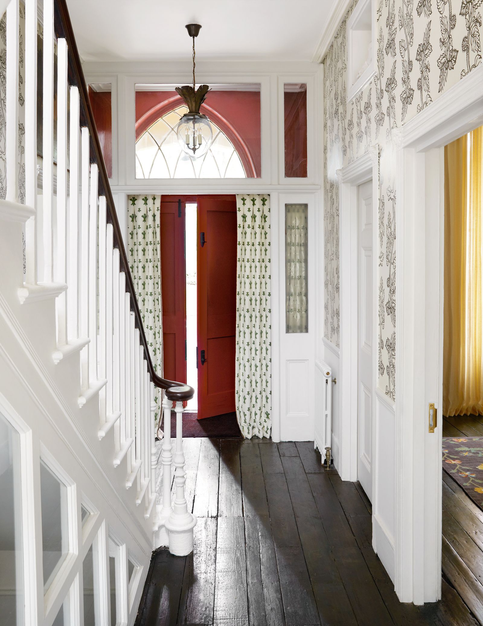 Beatas ‘Dodo Egg lantern illuminates the hallway with walls covered in her new ‘Nettle wallpaper and the door curtains...