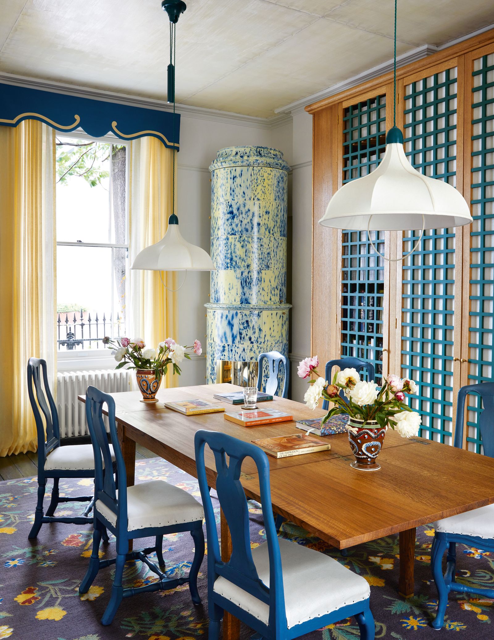 In the librarycumdining room of 188 Hammersmith Road W6 a wooden cabinet in the form of a kakelugn  stands beside a...