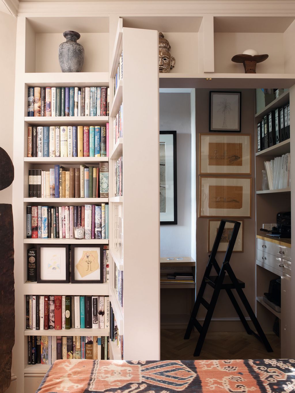 In this London flat the large set of bookshelves in the dining room incorporates jib doors that open into an office...