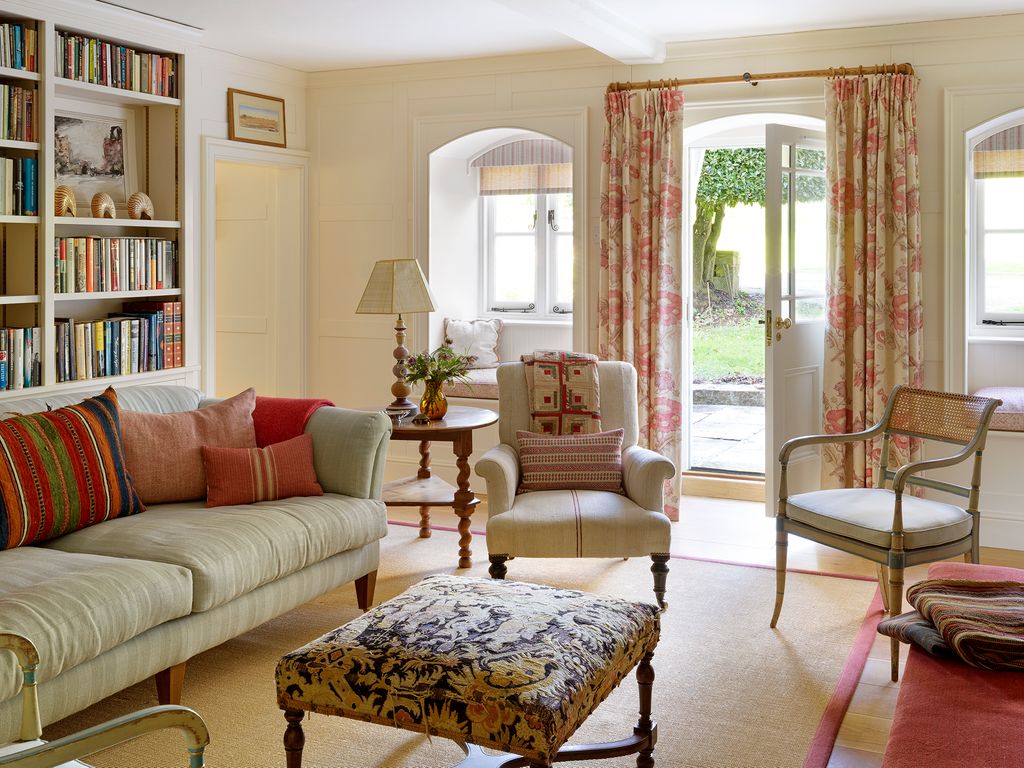 A side chair in an antique French linen from Robert Kime is decorated with a cushion in an antique fabric from Susan...