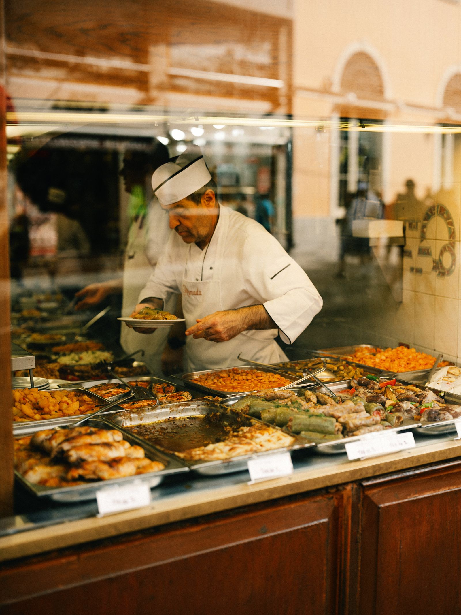 Image may contain Cafeteria Indoors Restaurant Food Meal Clothing Hat Adult Person Plate and Buffet