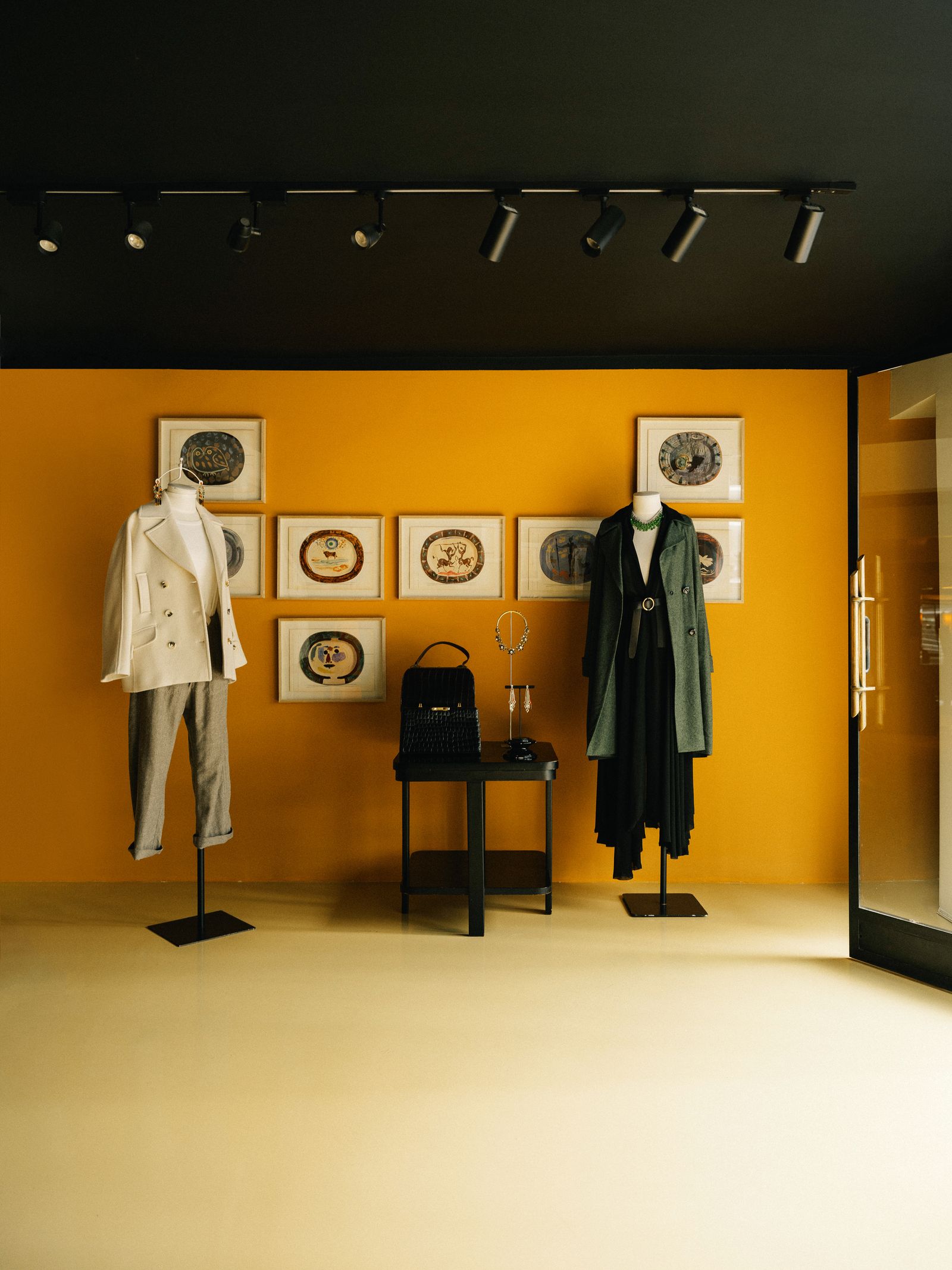 Image may contain Clothing Coat Art Painting Accessories Bag Handbag Person Jewelry Necklace Floor and Flooring