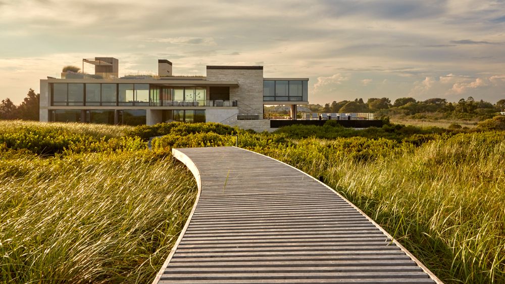 Image may contain Grass Plant Architecture Building House Housing Villa Water Waterfront Boardwalk and Bridge