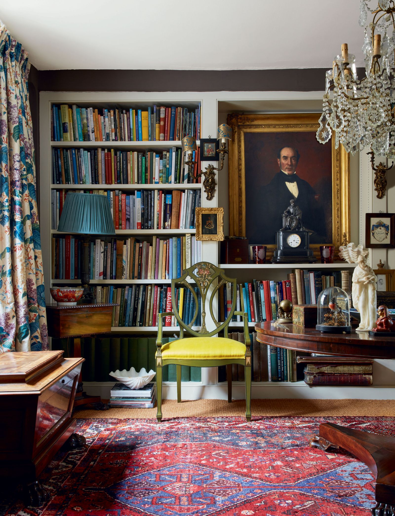 Image may contain Chair Furniture Art Painting Home Decor Rug Adult Person Bookcase Desk Table and Cup