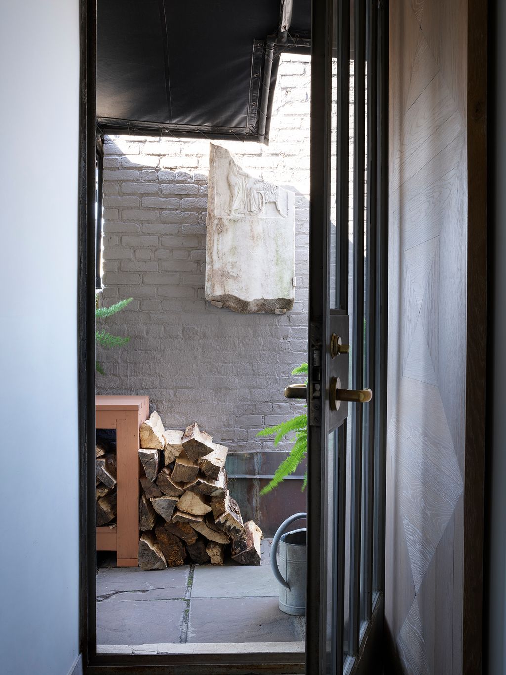 A lift drops visitors off on a verdant roof terrace with the door or the apartment tucked around a corner.