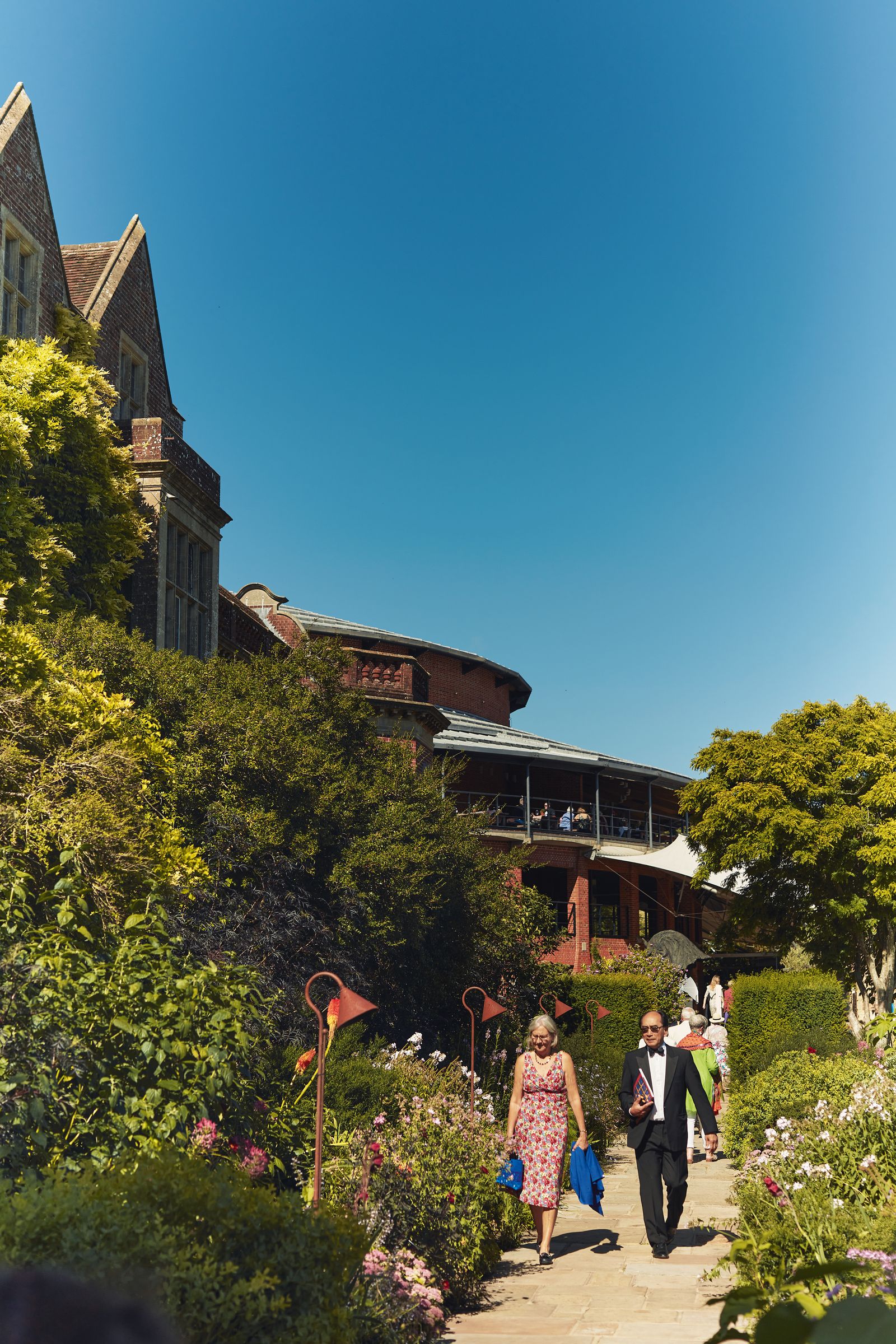 Image may contain Person Walking Neighborhood Grass Plant Vegetation Potted Plant Tree Photography Adult and Face