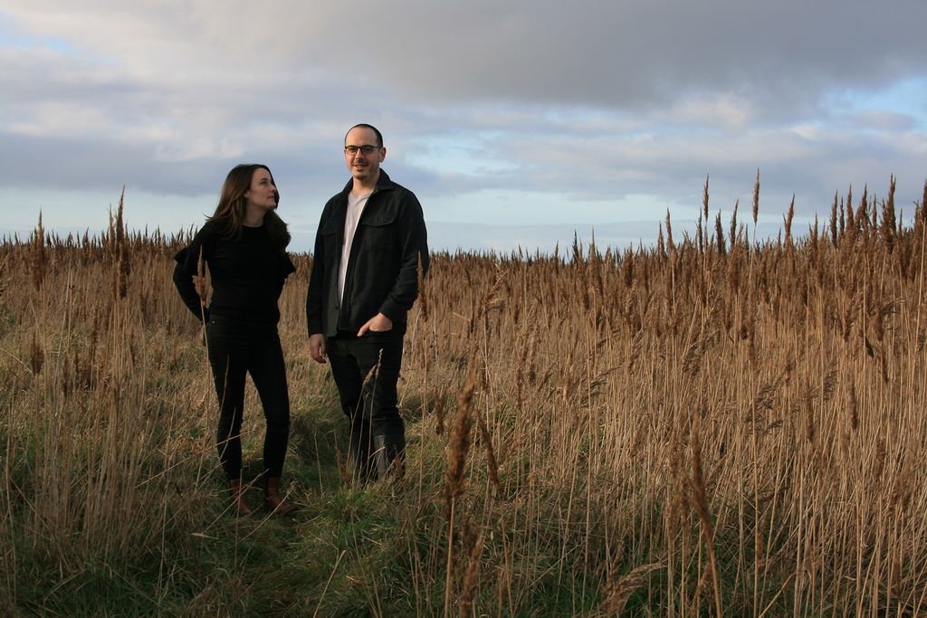 Image may contain Blazer Clothing Coat Jacket Adult Person Grass Plant Body Part Hand Formal Wear and Suit