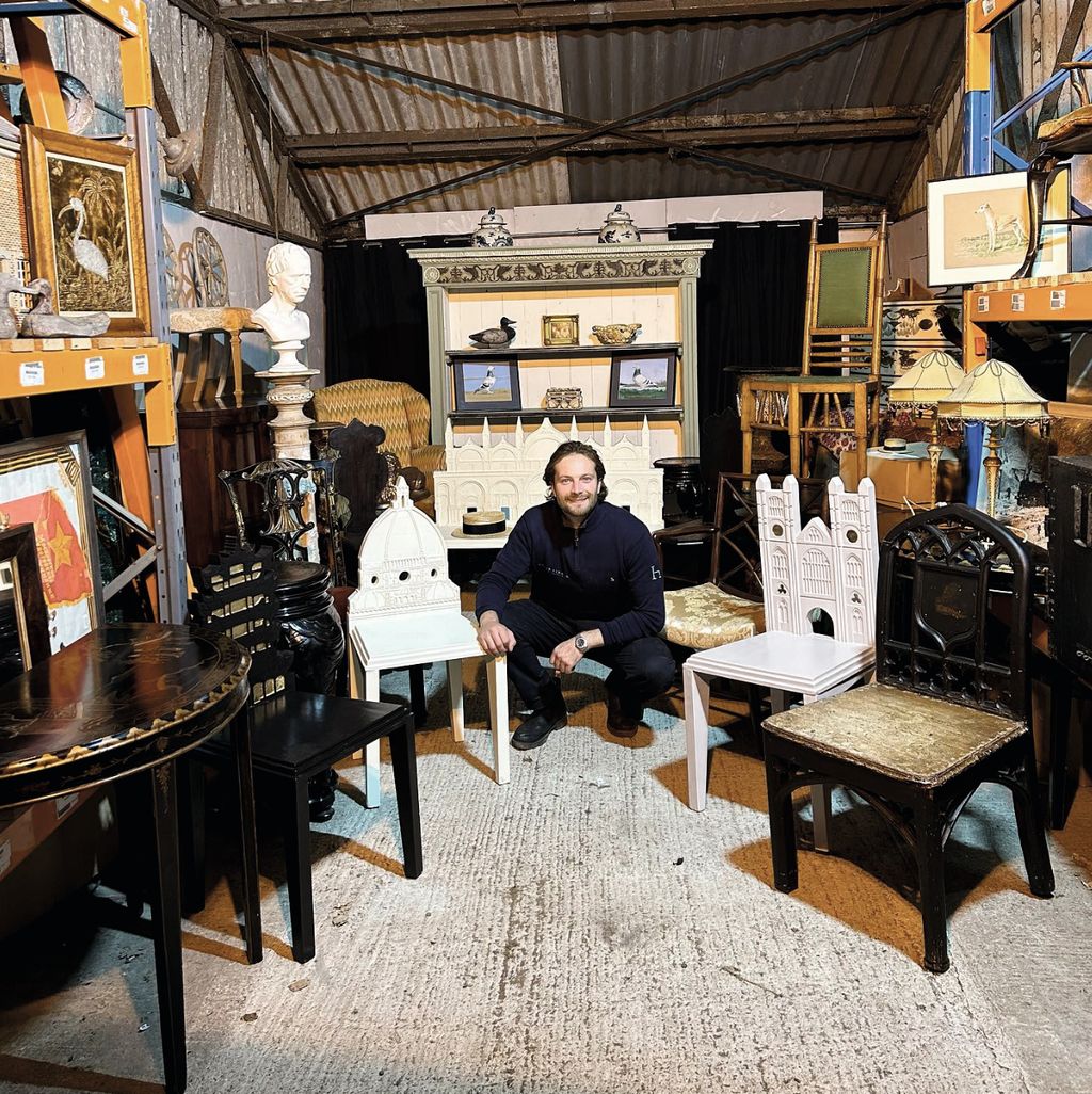 Image may contain Plywood Wood Adult Person Desk Furniture Table Chair Wristwatch Clothing Footwear Shoe and Art