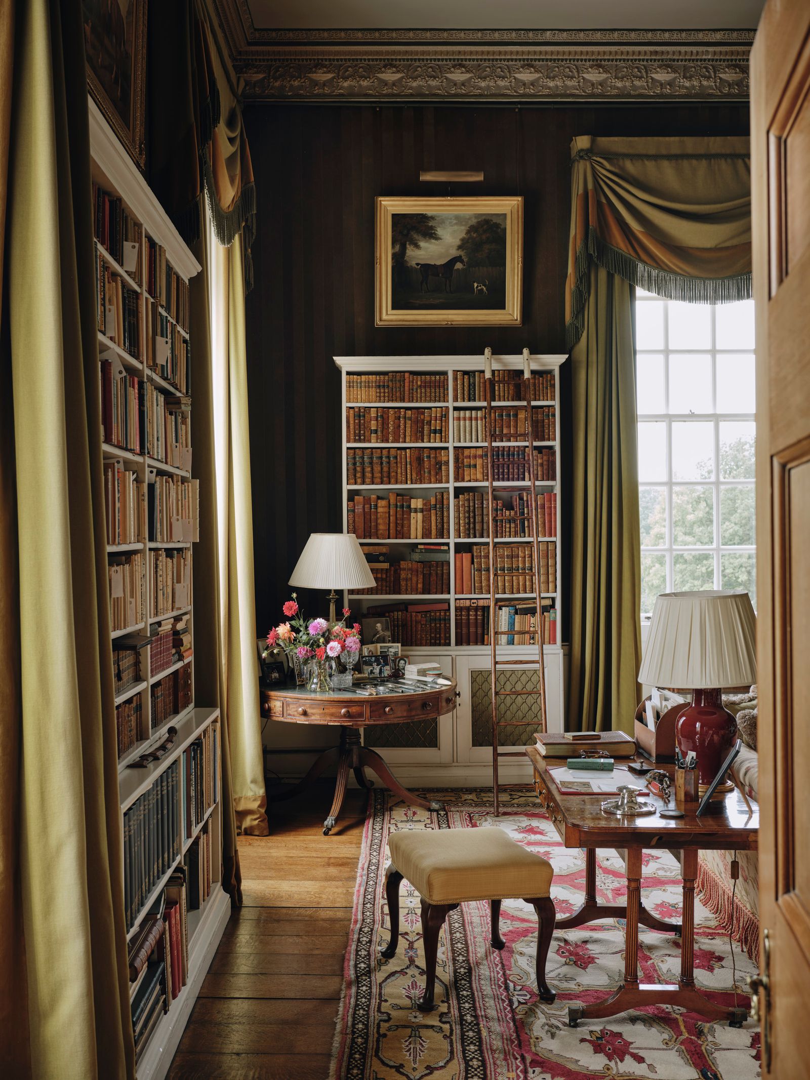 Image may contain Desk Furniture Table Indoors Interior Design Lamp Home Decor Rug Art Painting and Bookcase