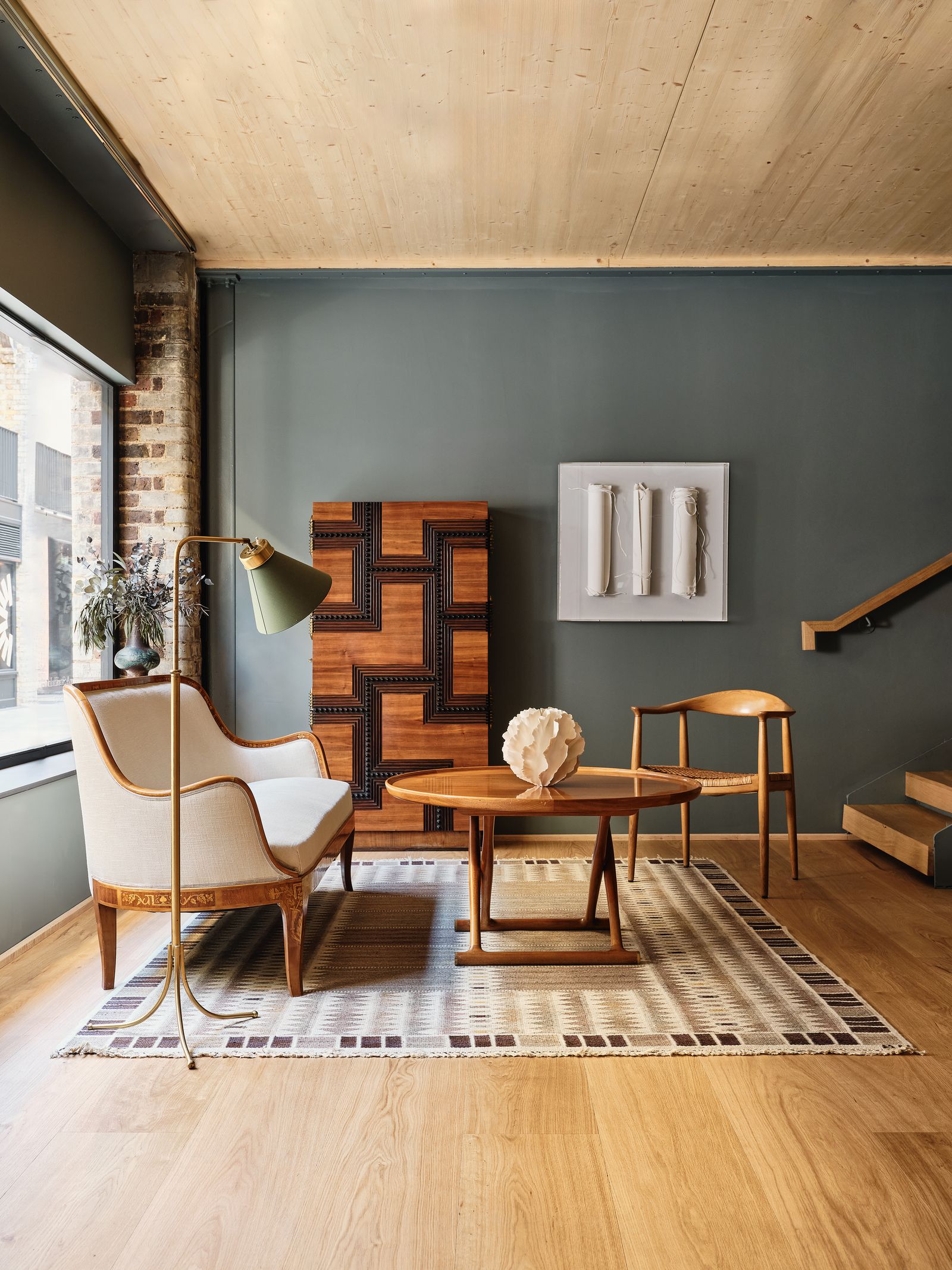 Image may contain Indoors Interior Design Home Decor Rug Desk Furniture Table Chair Coffee Table Floor and Wood