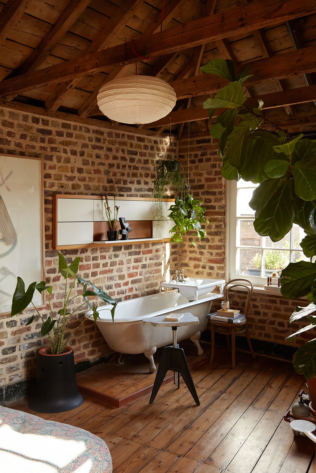 Image may contain Indoors Interior Design Wood Hardwood Chair Furniture Plant Floor Flooring Lamp Sink and Book