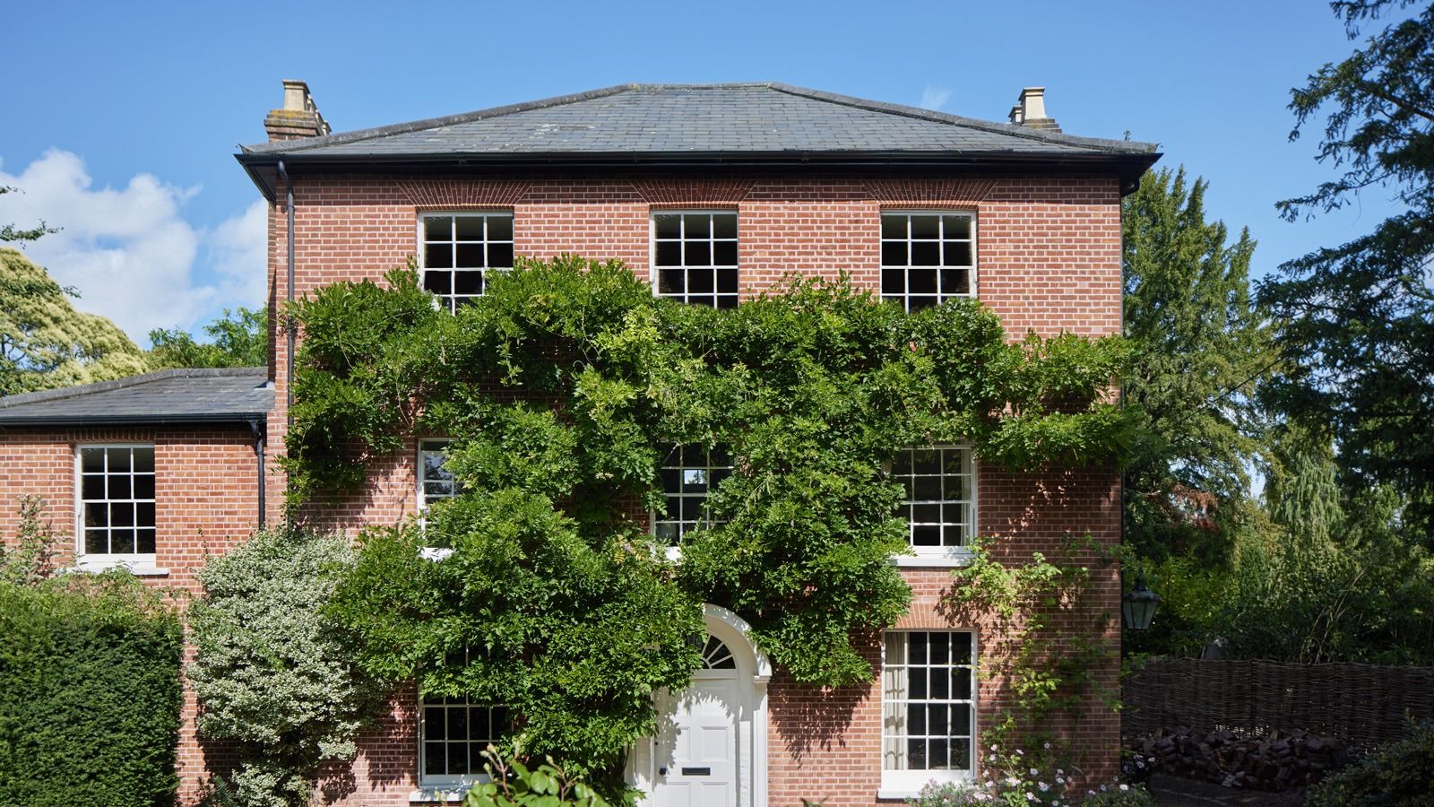 Image may contain: Architecture, Building, Cottage, House, Housing, Villa, Manor, Plant, Tree, Door, and Vegetation