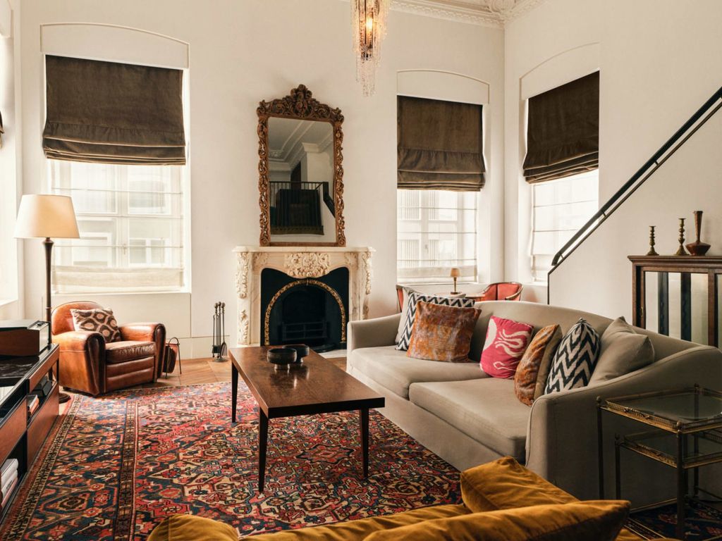 Image may contain Home Decor Couch Furniture Lamp Rug Architecture Building Indoors Living Room Room and Table