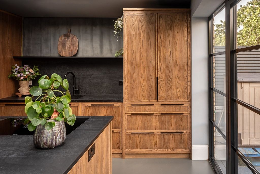 Image may contain Indoors Interior Design Hardwood Wood Stained Wood Plant Sink Sink Faucet Wood Panels and Kitchen